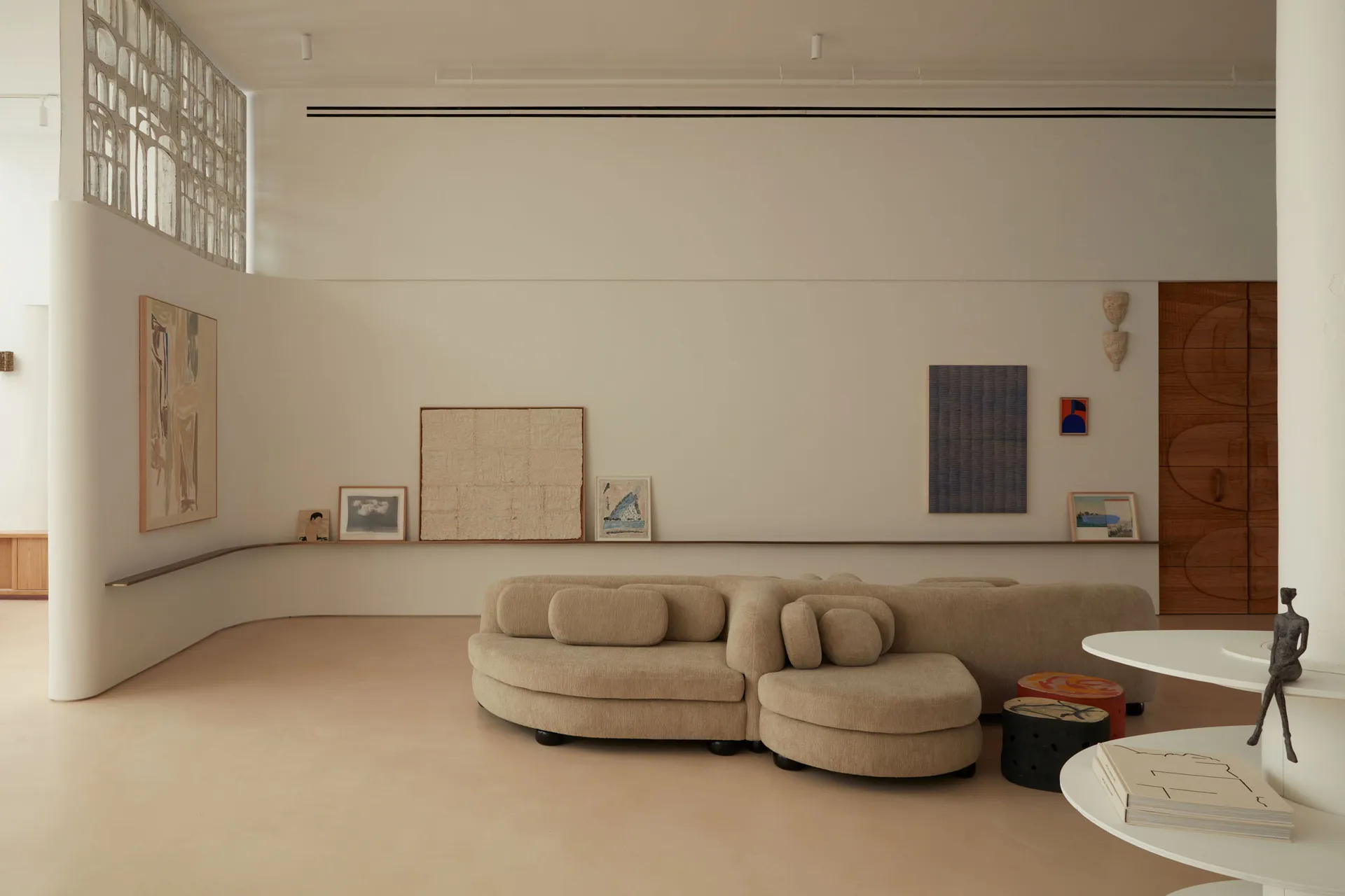 A minimalist living room with neutral-toned furniture and wall decor.