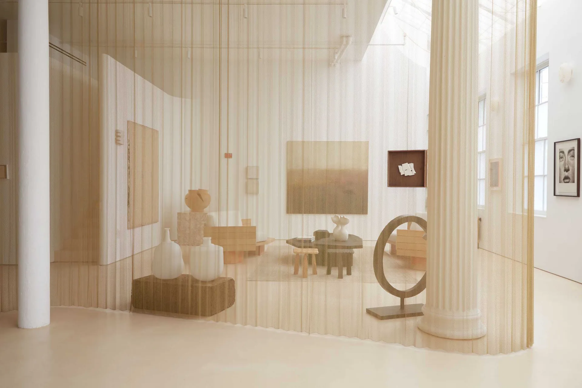 An installation art piece featuring textiles in a spacious, minimalist room.
