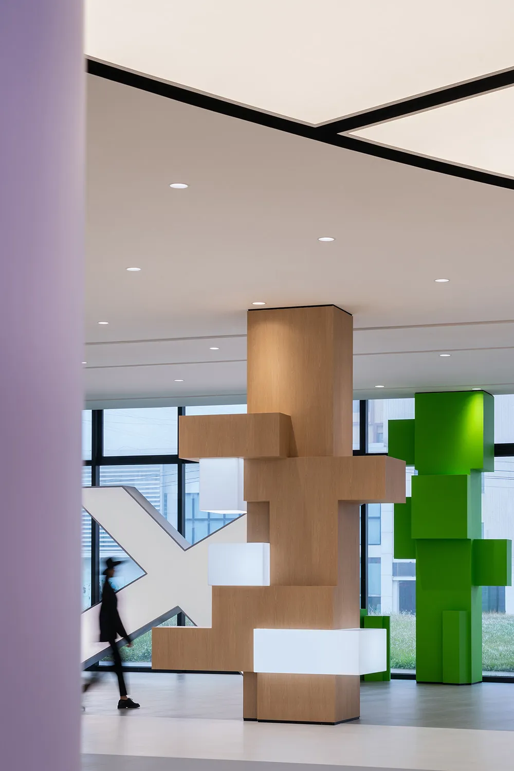 A modern office space featuring wooden panels, glass elements, and concrete finishes.