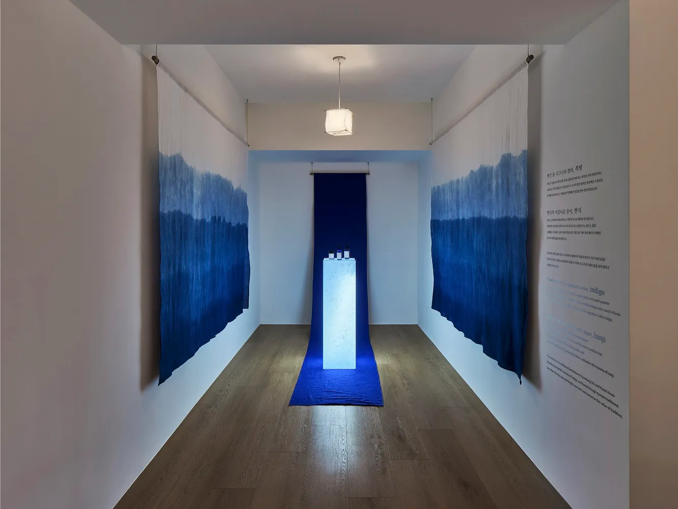 An industrial installation with blue gradient fabric walls creating a minimalist aesthetic.