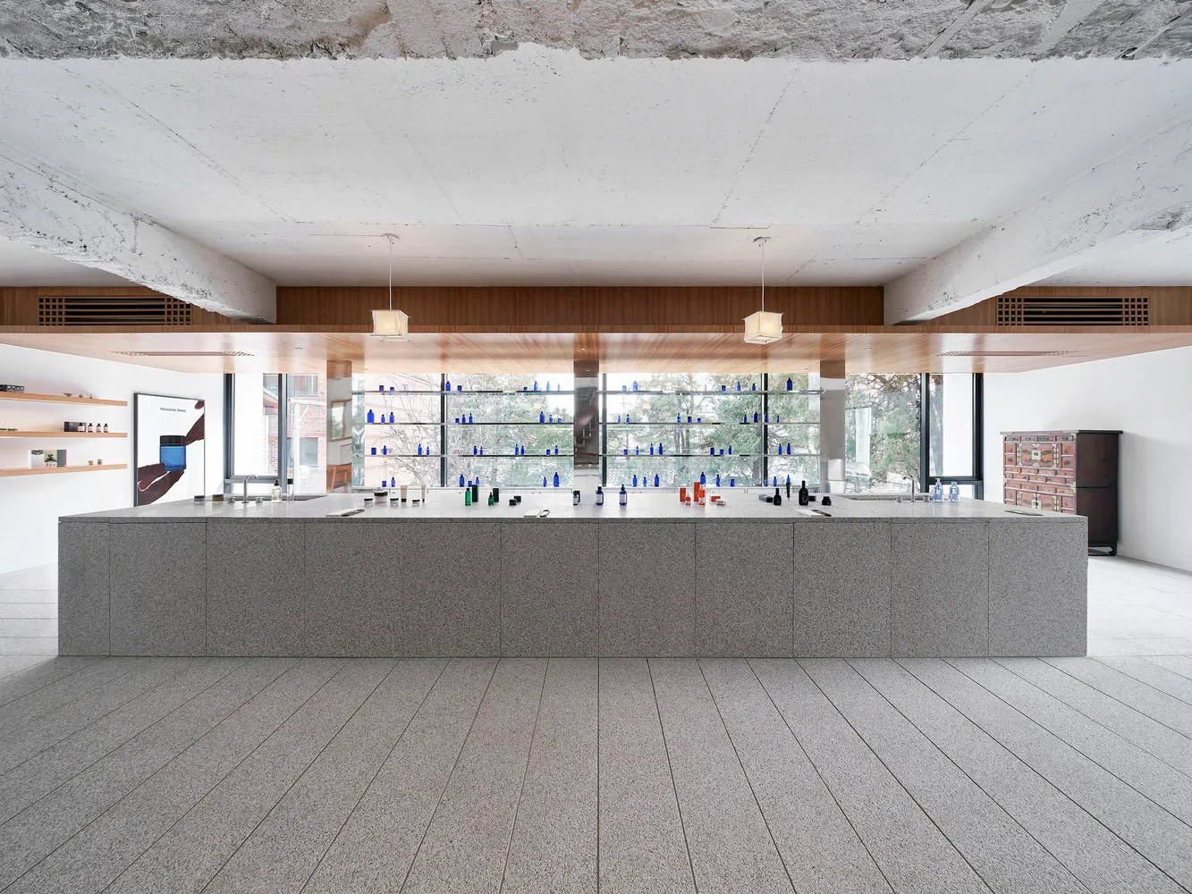 A minimalist bar counter made of granite with shelves lined with bottles.