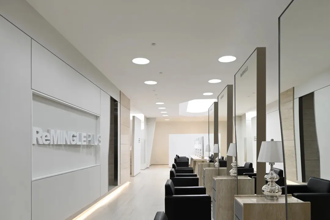 A modern minimalist waiting room with glass, wood, and leather accents.