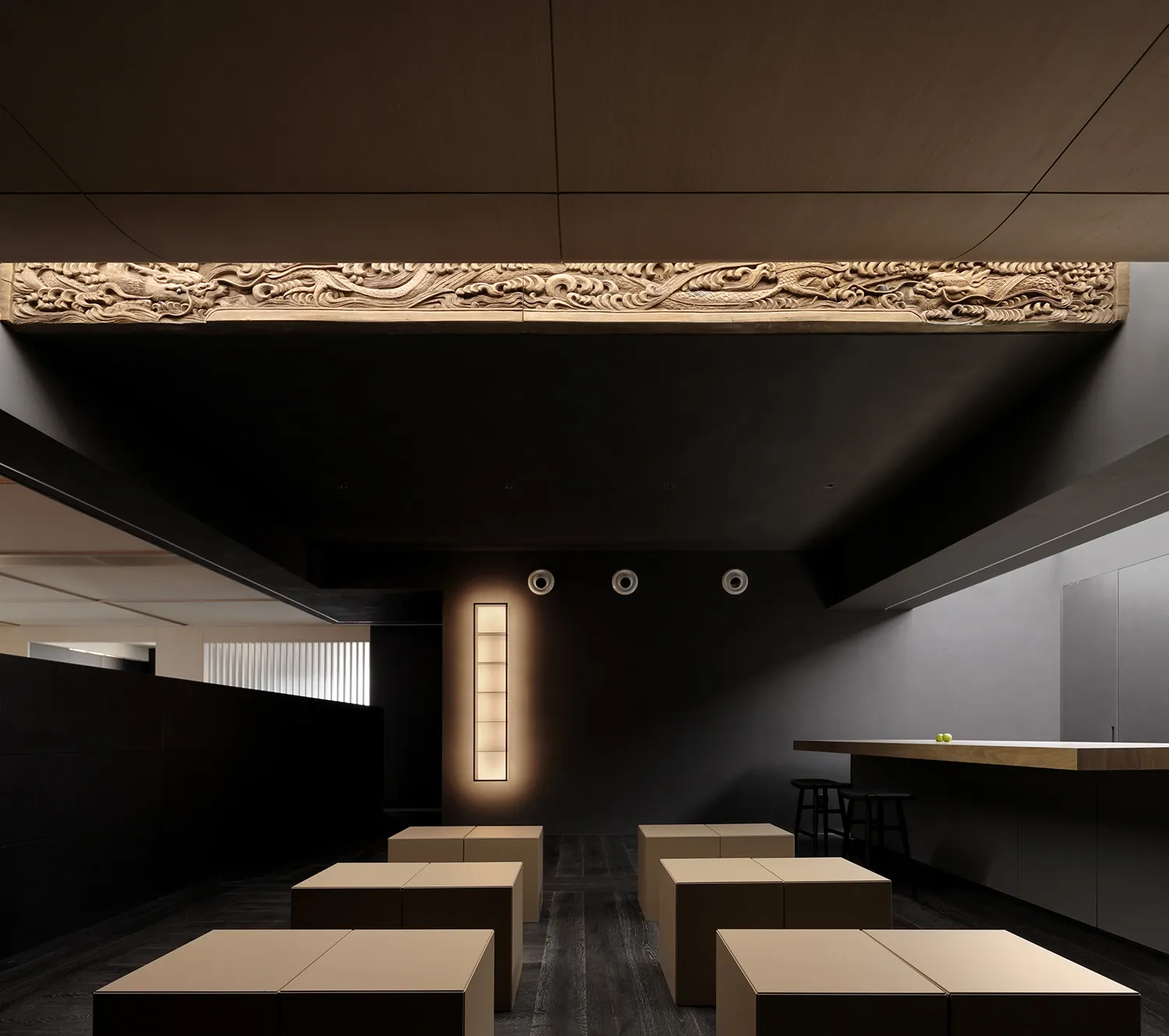 A minimalist restaurant interior featuring dark wood furniture and black light fixtures.