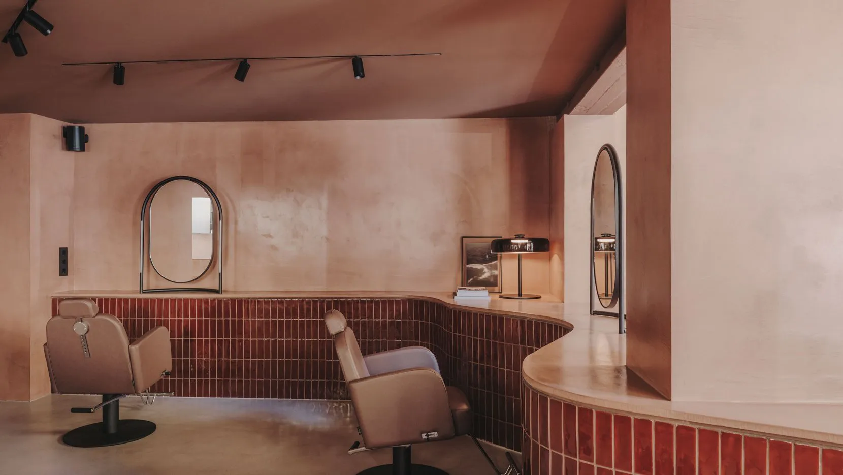 Minimalist interior design of a salon with wooden furniture and a concrete floor.