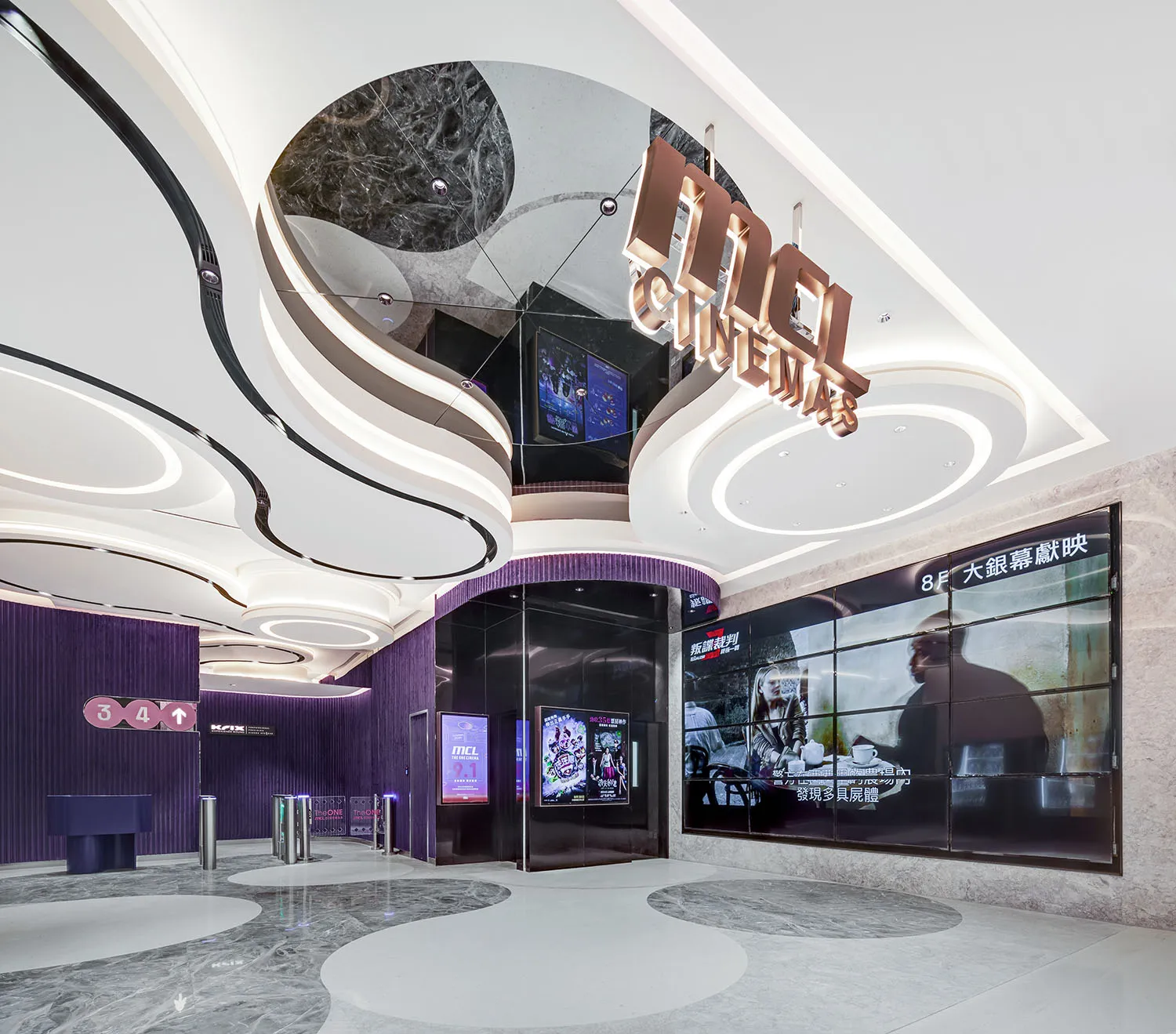 Modern cinema entrance featuring concrete and marble design elements.