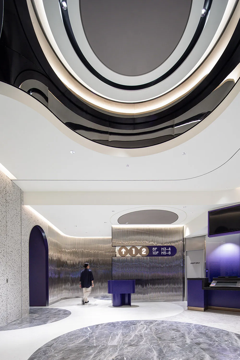 A modern lobby featuring a combination of metal, concrete, and marble materials.