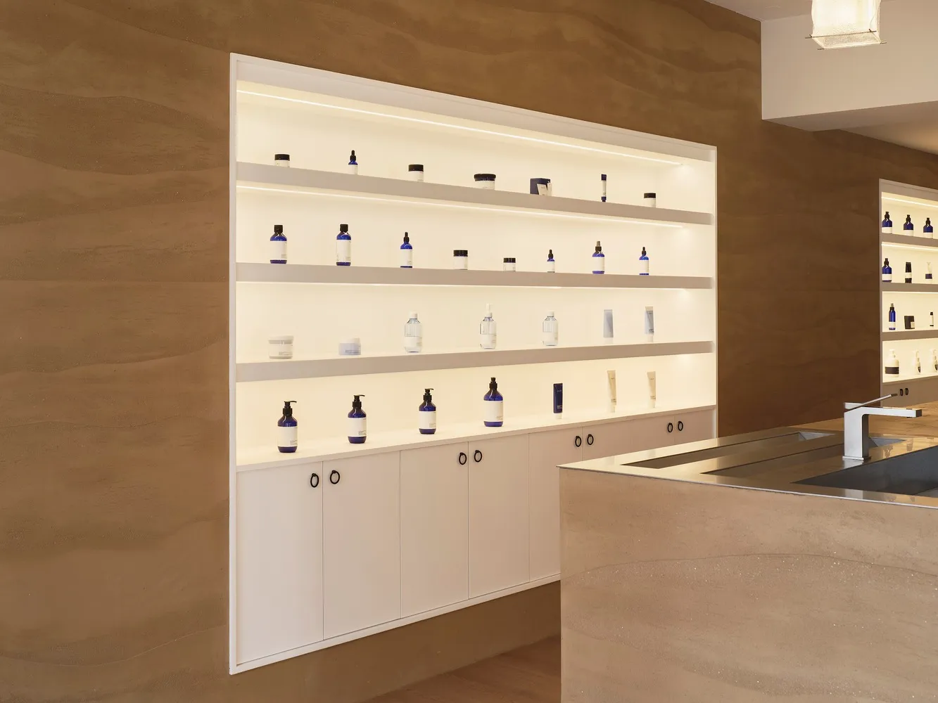 Shelves in a retail store featuring modern concrete shelving units filled with various blue-labeled products.