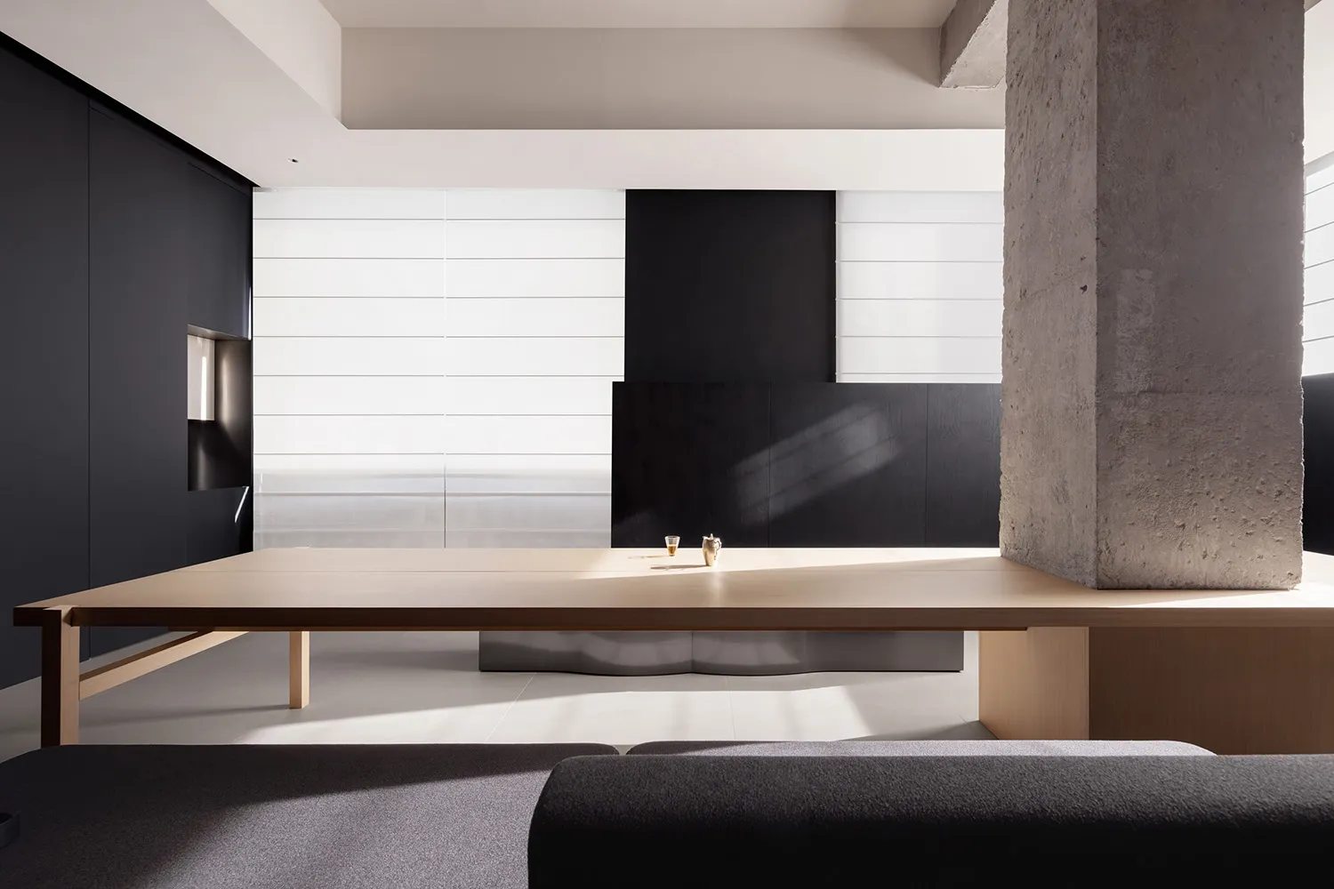 A minimalist residential interior design featuring concrete, wood, and solid surface materials.