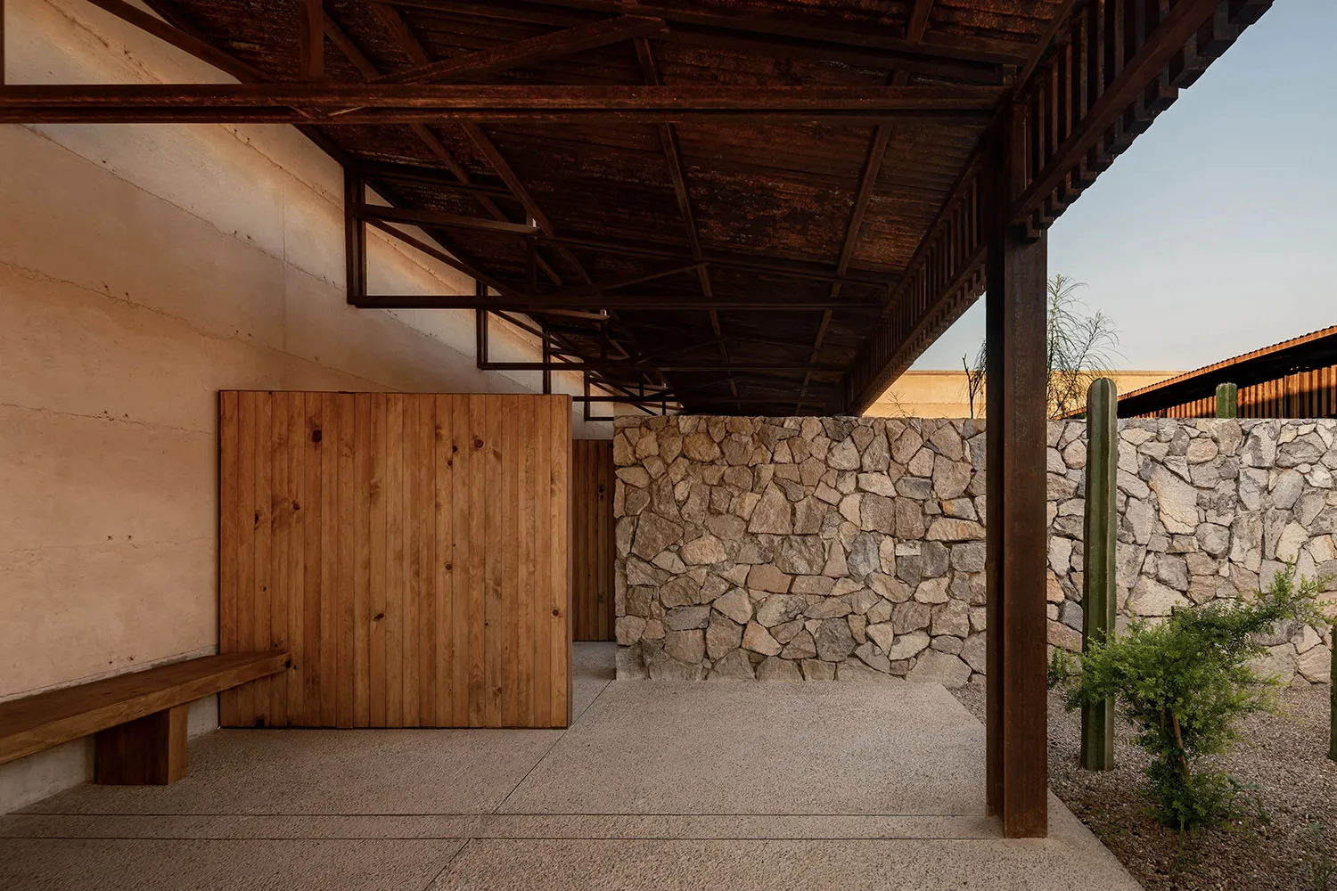 A minimalist architectural interior featuring stone, concrete, and wood materials.