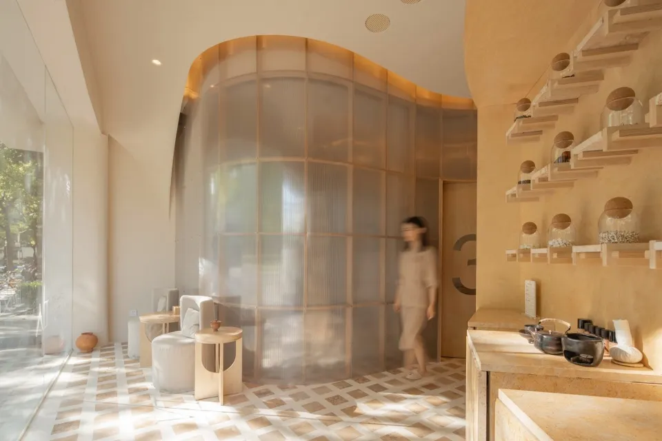 A serene minimalist spa interior featuring wooden seating, transparent glass walls, and natural light.