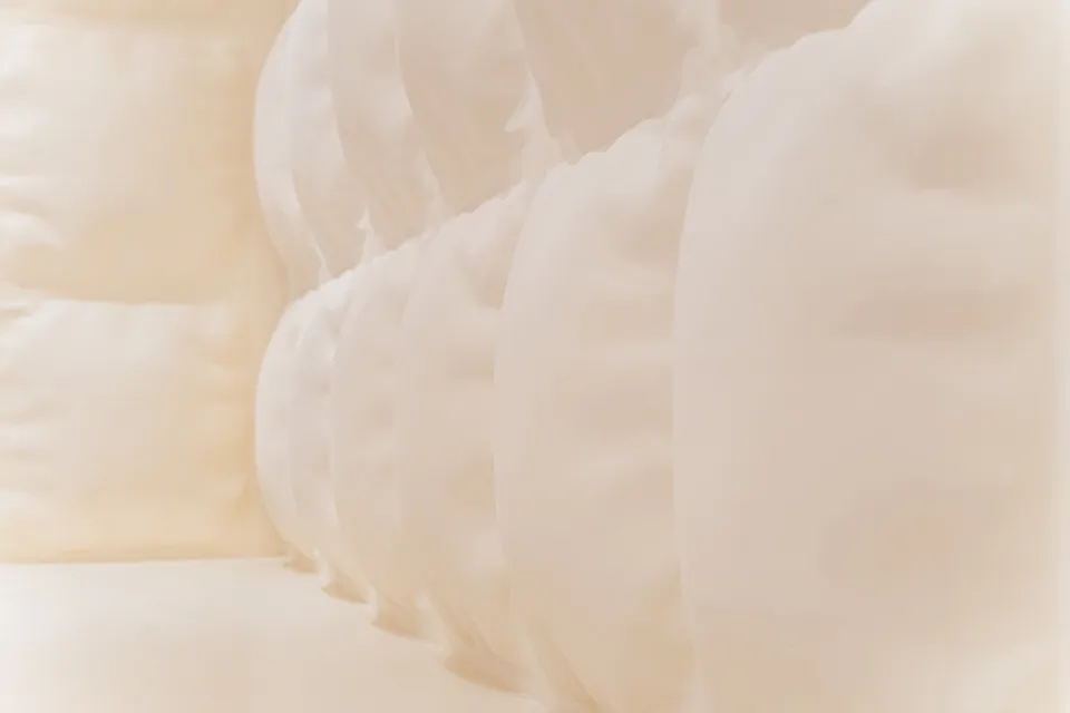 A modern bedroom with white pillows on a bed.