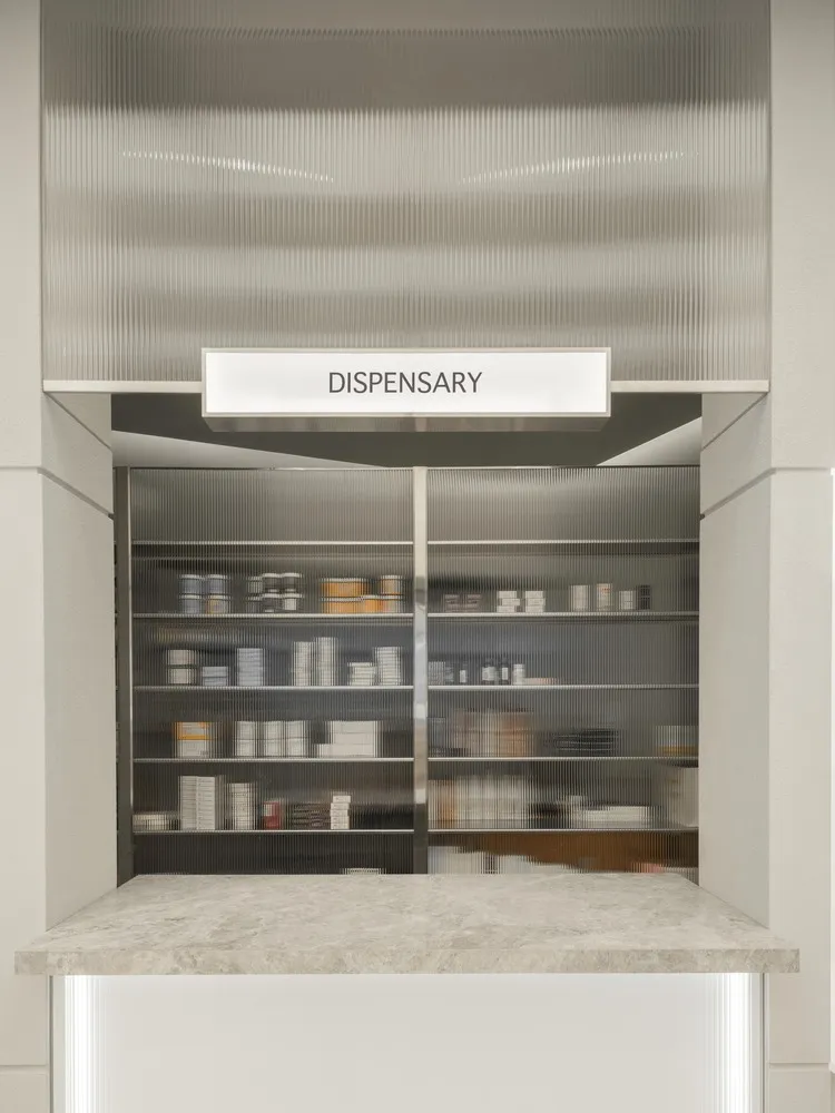 Modern dispensary with metal, glass, and concrete shelving.