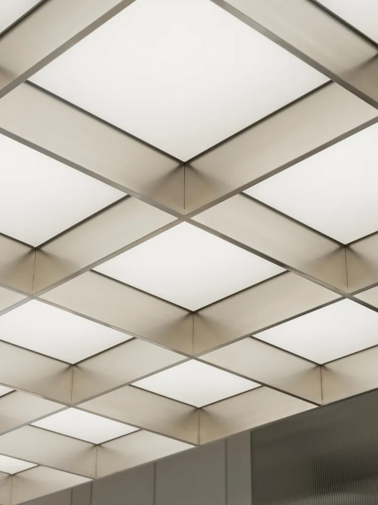 Metallic ceiling panels with integrated lighting fixtures for modern interior design.