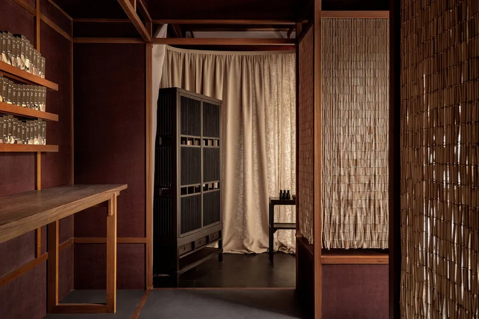 Minimalist living space featuring wooden furniture, fabric curtains, and traditional design elements.