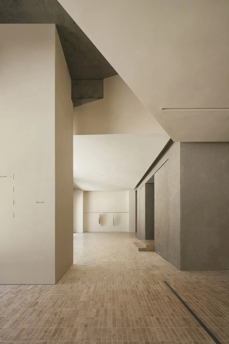 A modern interior space featuring concrete walls and travertine tile flooring.