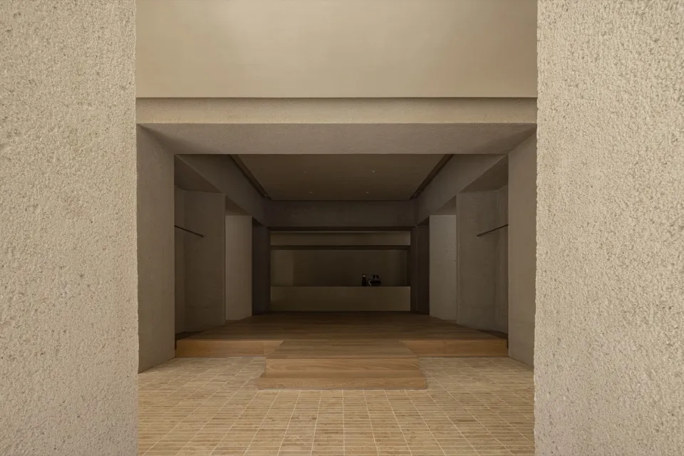 A minimalist concrete entrance with a wooden floor and minimalist design elements.