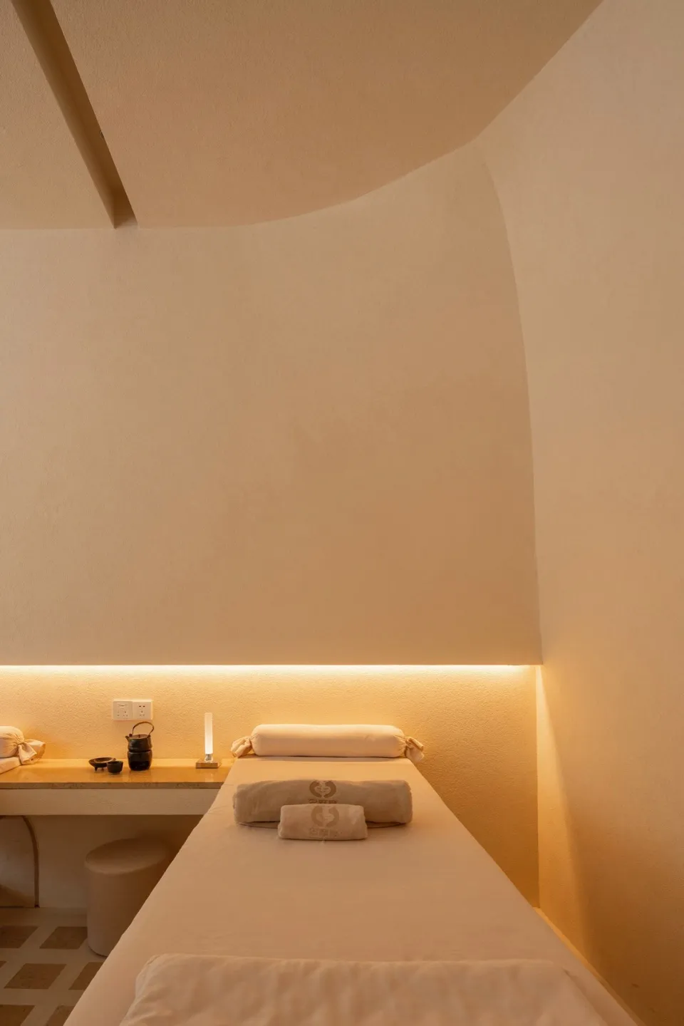 Neutral-colored spa room with minimalist design features and soft lighting.