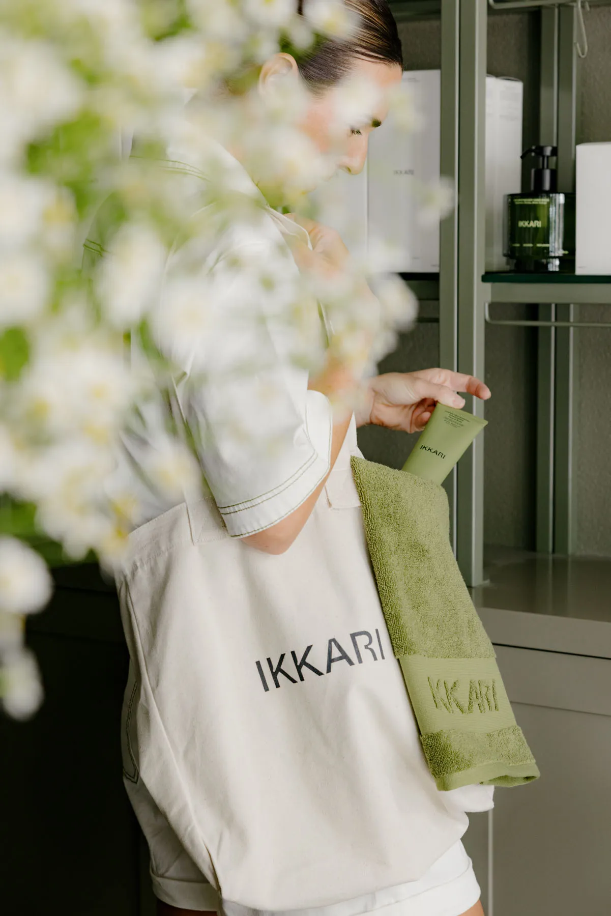 一位人士手持綠色 Ikkari 袋,內裝浴巾與盥洗用品。
