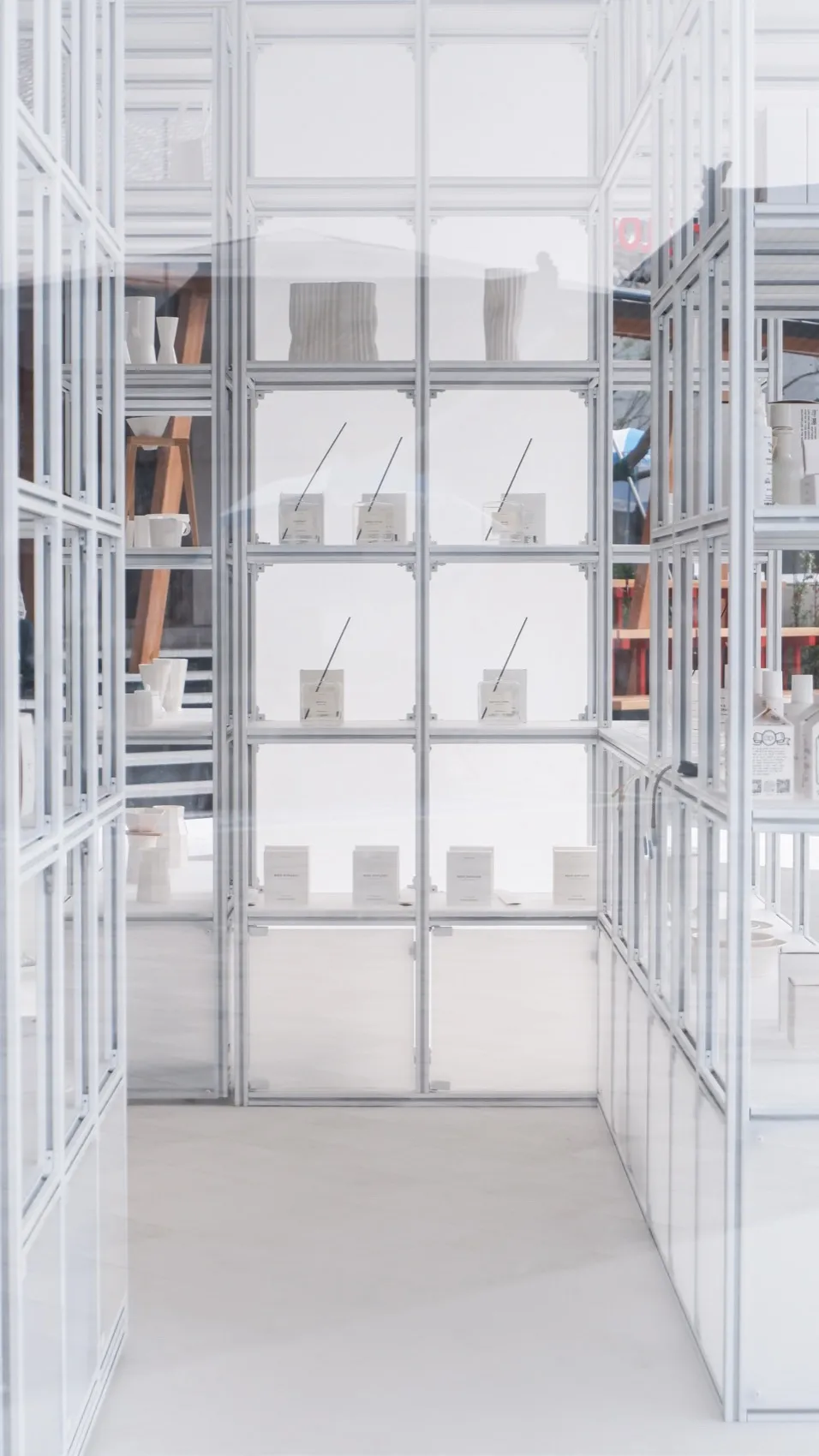 Minimalist retail space featuring glass displays and white shelves.
