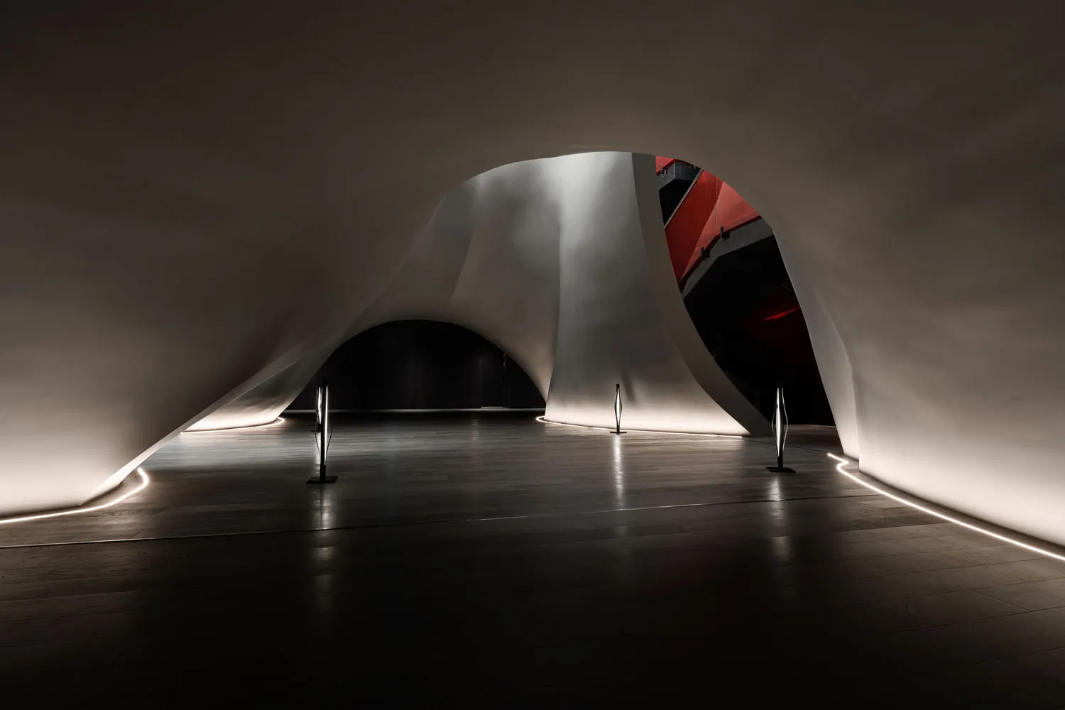 Modern interior design featuring curved concrete forms and a minimalist aesthetic