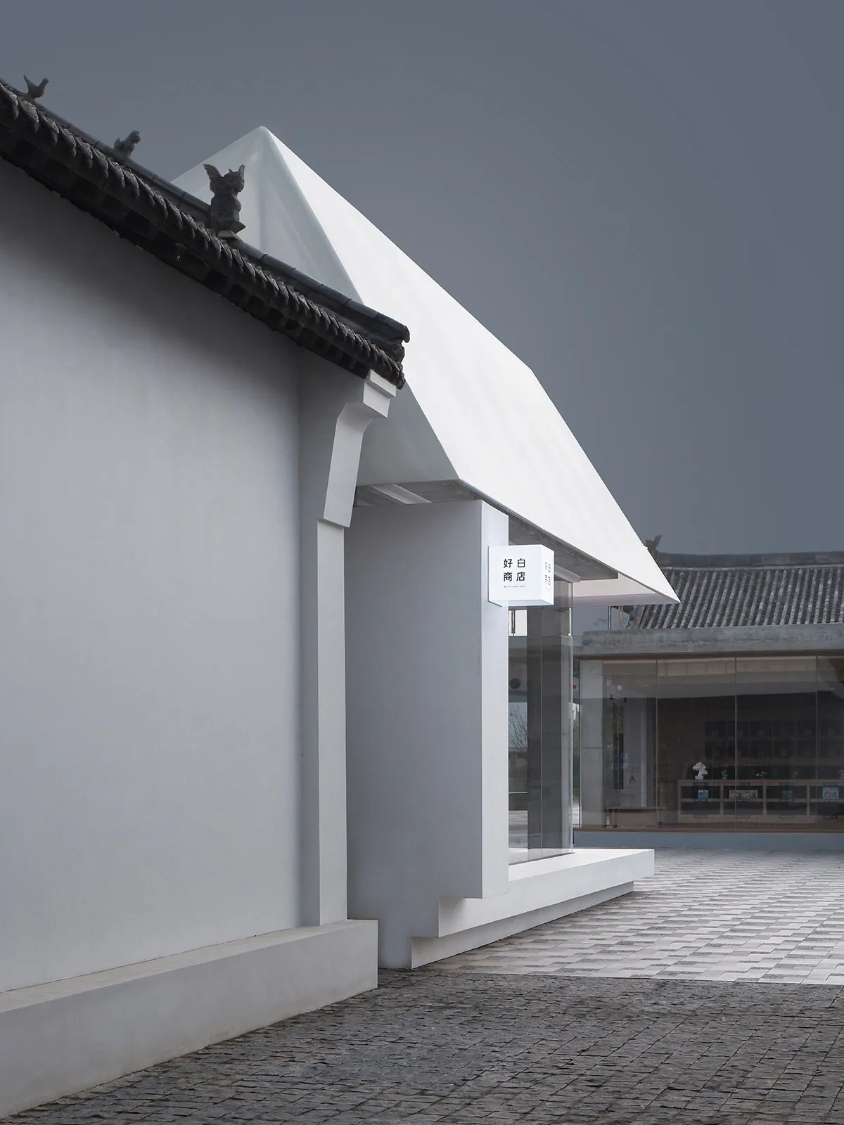 Modern retail storefront with white stone exterior and glass doors.