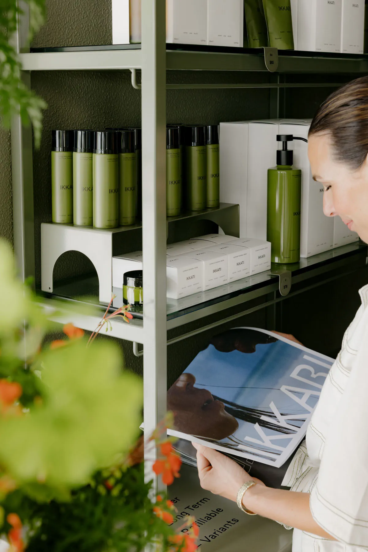 A modern interior shelf displaying minimalist cosmetic products and magazines.