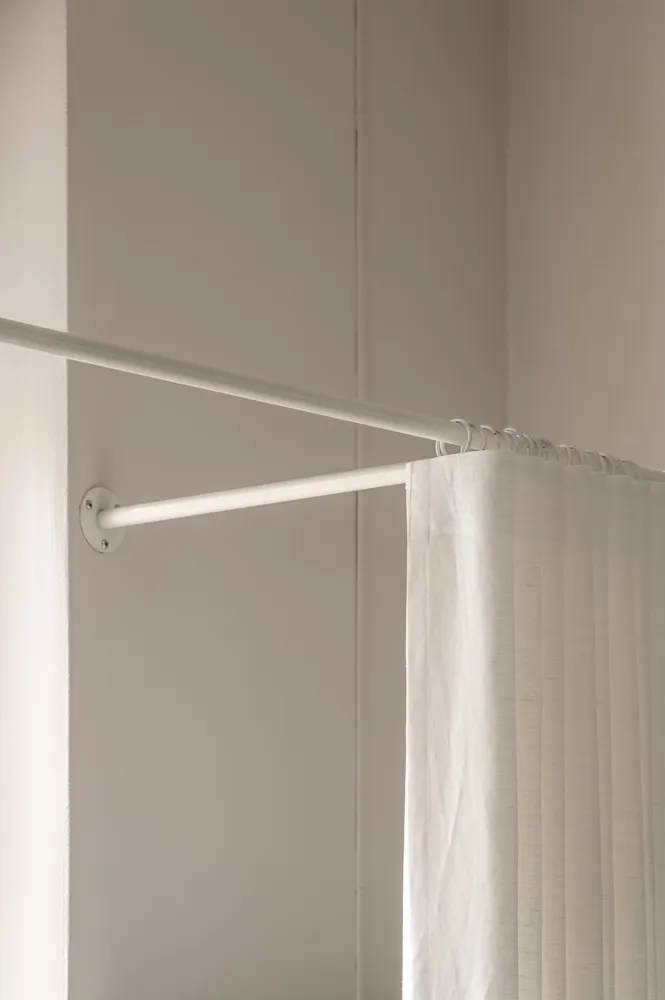 A white curtain on a minimalist rod in a modern living space