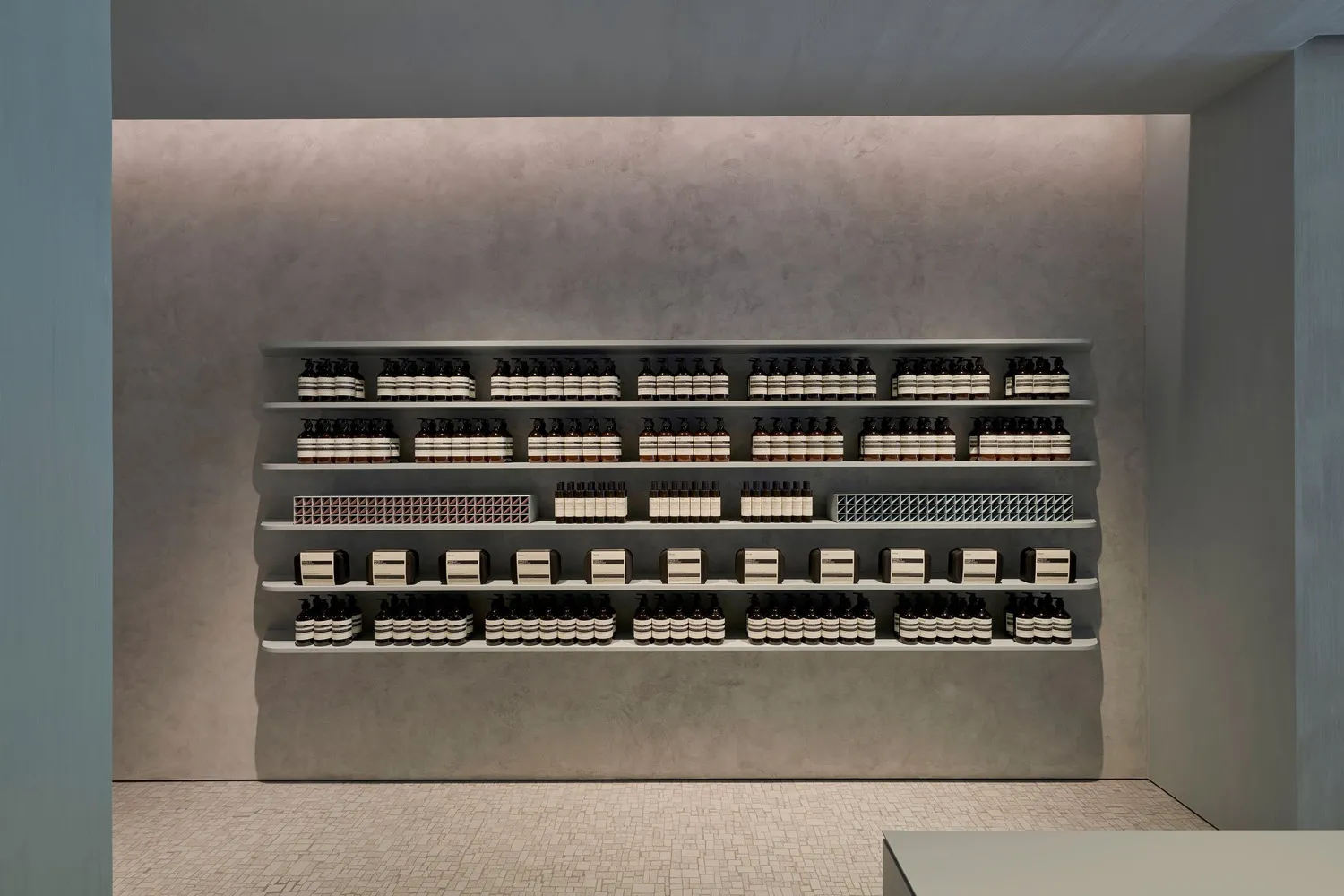 A modern retail store with concrete shelving and tiled floors.