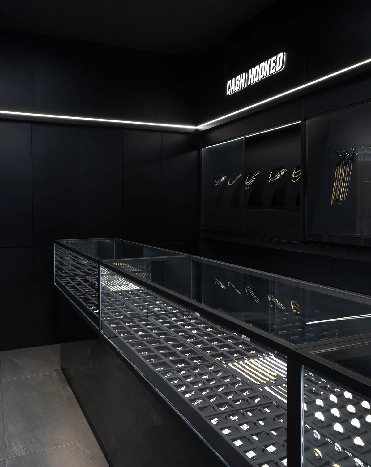 A contemporary jewelry display in a modern retail store showcasing elegant glass and metal fixtures.