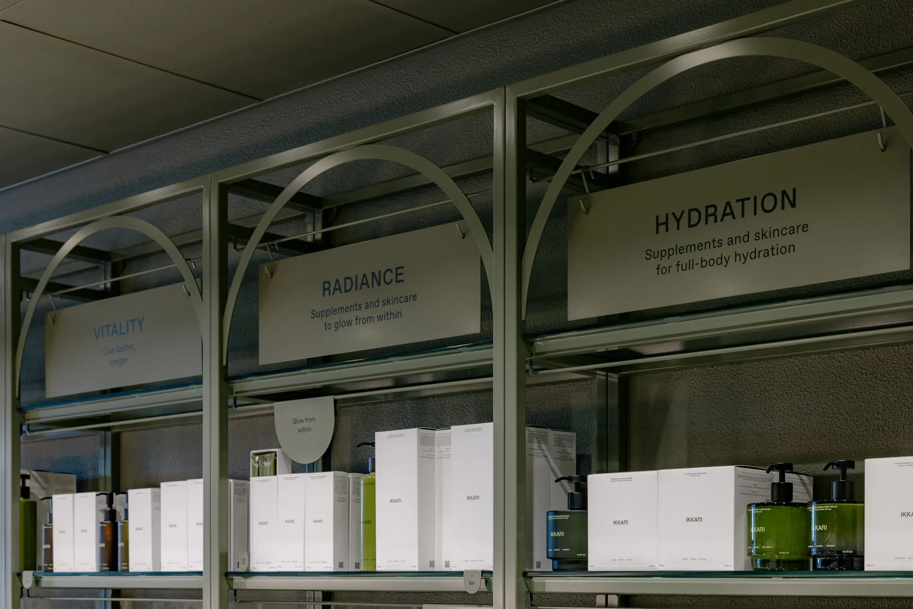 金屬展示架上擺放著寫有「Radiance」、「Hydration」和「Vitality」的標牌,陳列著保養品。