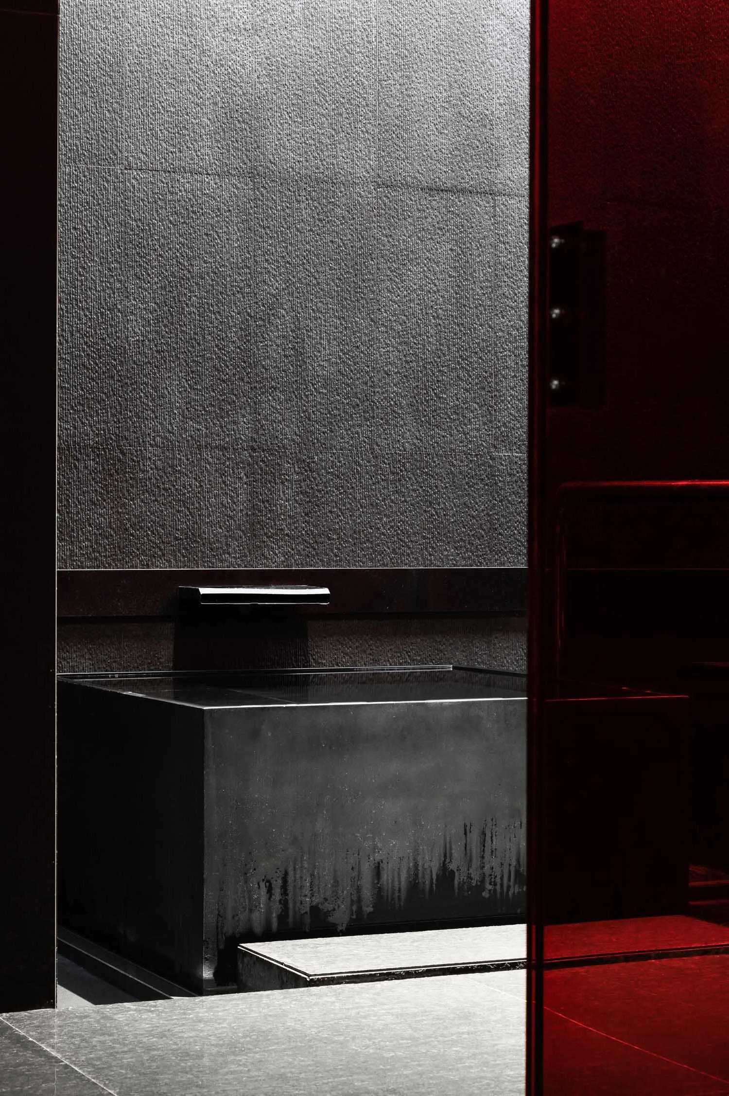 Concrete bathtub and shower enclosure in an industrial-style bathroom