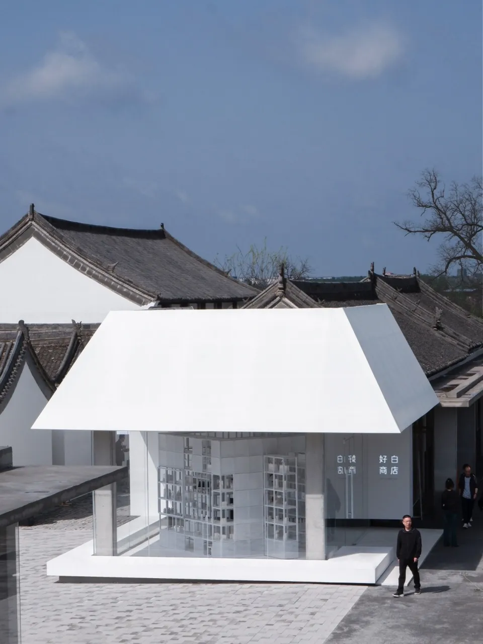 A sleek, modern retail storefront with glass walls and a large overhang.