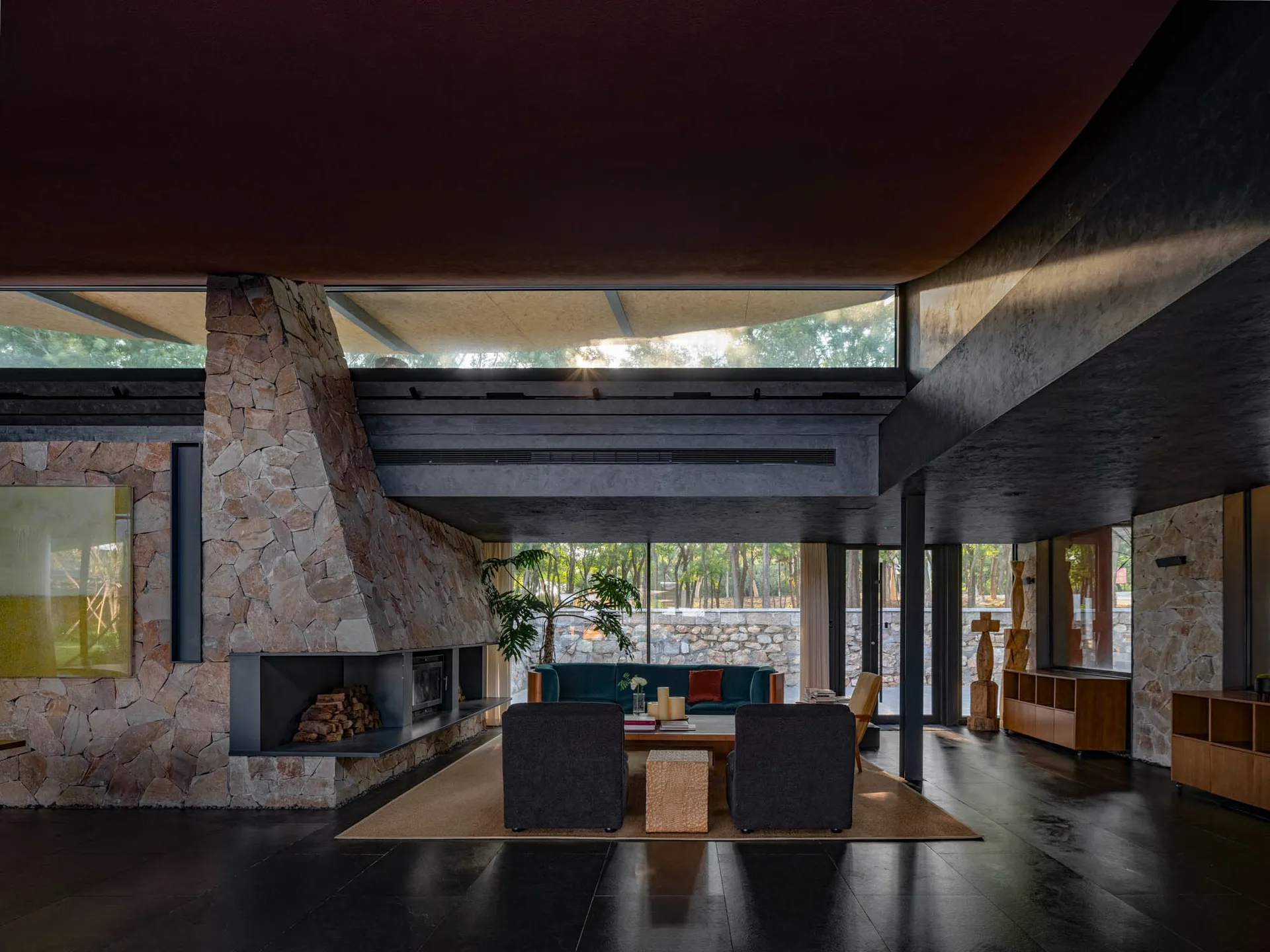 A modern living room with concrete walls and stone flooring.