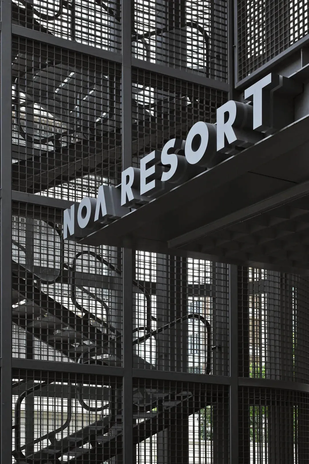 一面工業風金屬牆飾,上面刻有「Noa Resort」字樣。