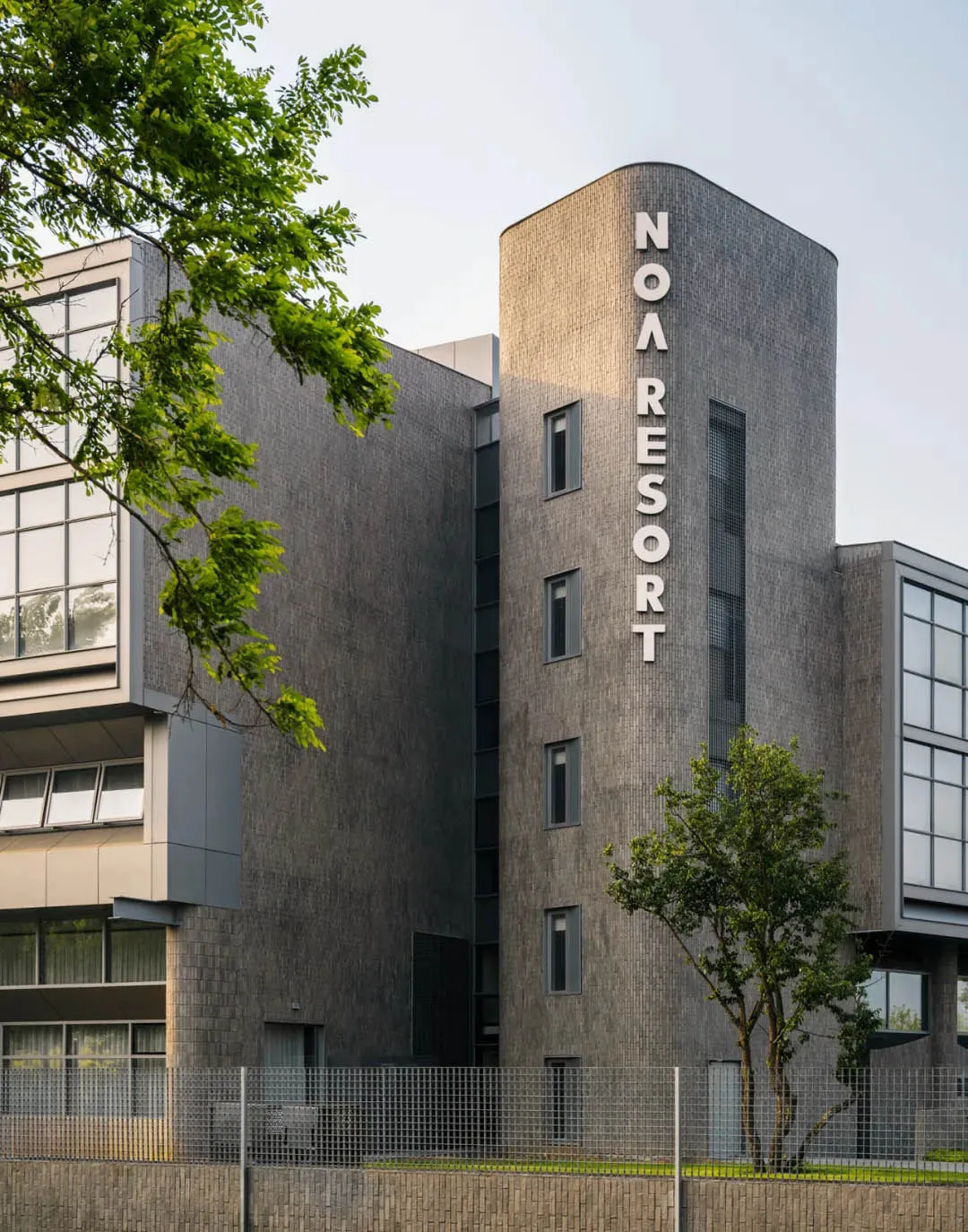 A modern office building with a grey concrete exterior and large windows.