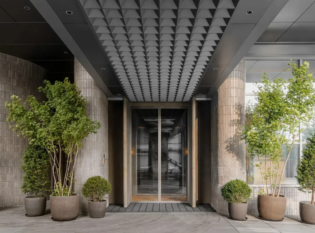 A modern entrance with concrete walls and a glass door.