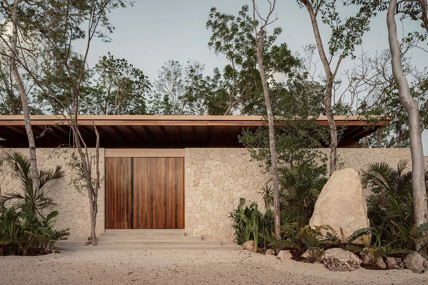 A minimalist house with a stone exterior and wooden accents.