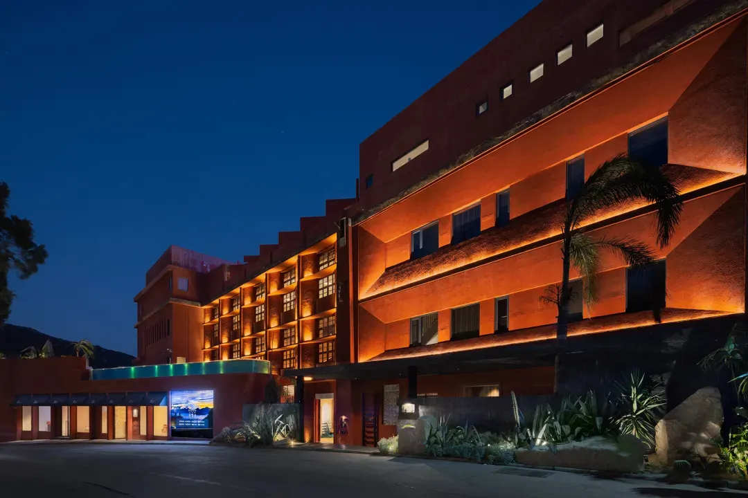 Modern architectural exterior of a building with concrete material and warm lighting at dusk.
