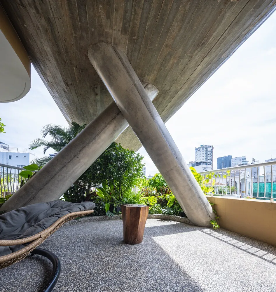 Modern patio with concrete columns, plants, and city skyline view.