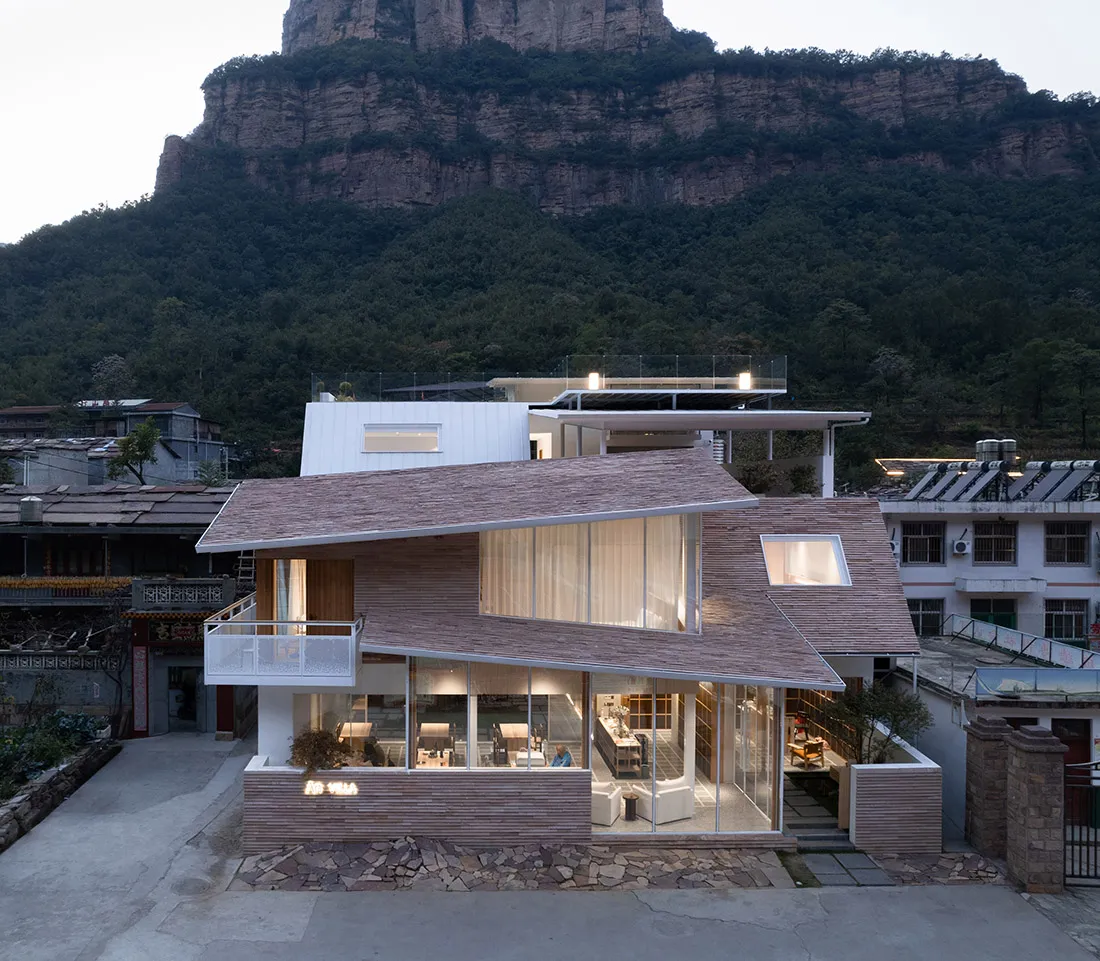 一座現代住宅木質框架棚屋,搭配木質外牆與大型玻璃窗。