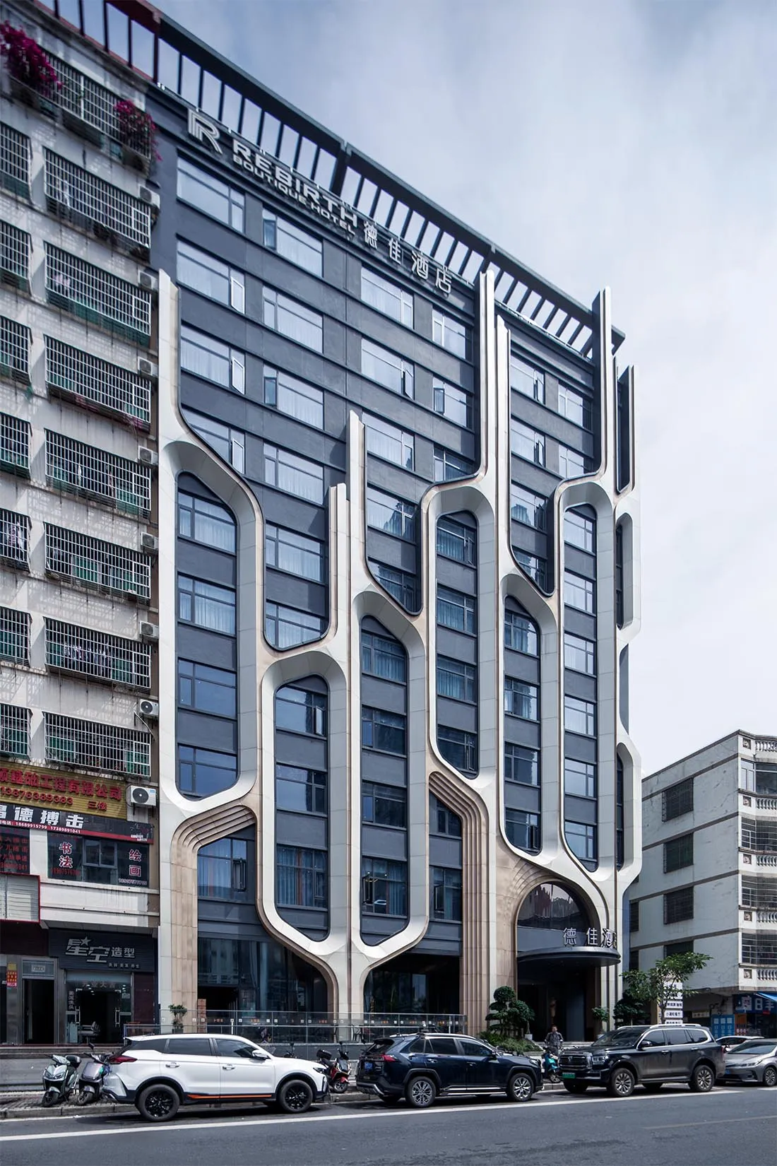 現代建築外觀,採用混凝土與玻璃材質,置於都市環境中。