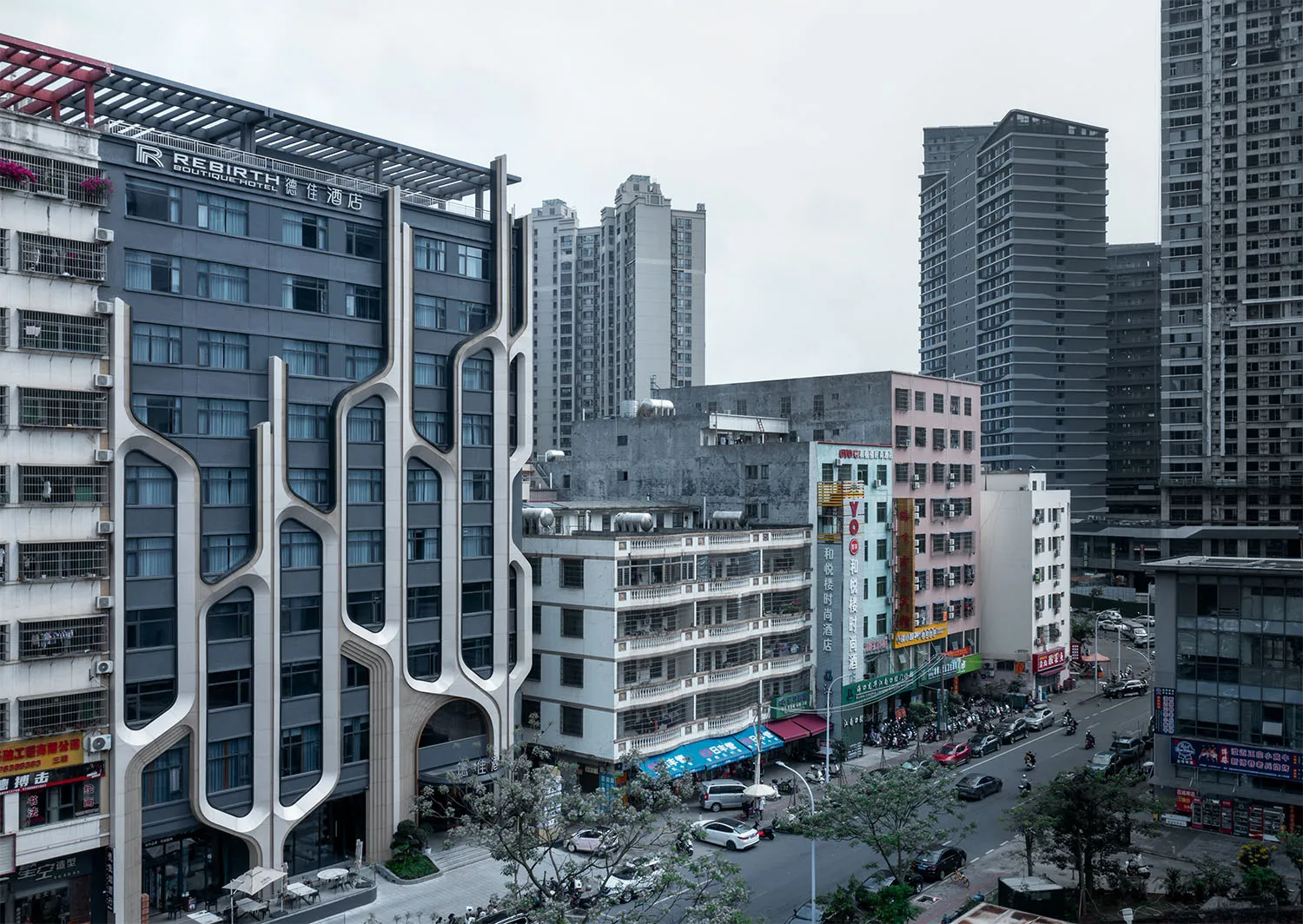 A modern urban streetscape featuring a variety of buildings with unique architectural designs and a bustling street filled wi