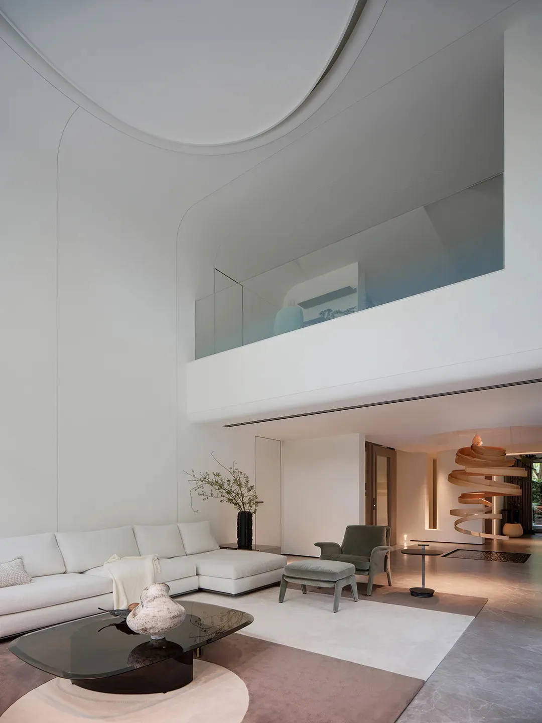 A modern, minimalist living room with white furniture and a sleek, curved design.