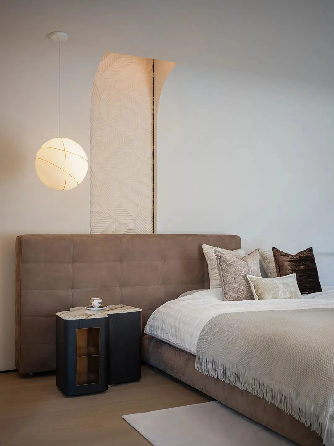 Modern minimalist bedroom featuring plush velvet bedding, marble nightstand, and wooden accents, showcasing sophisticated des