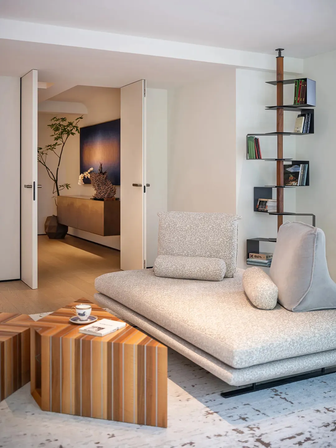 Minimalist living room with textured fabric furniture and geometric wooden coffee table.