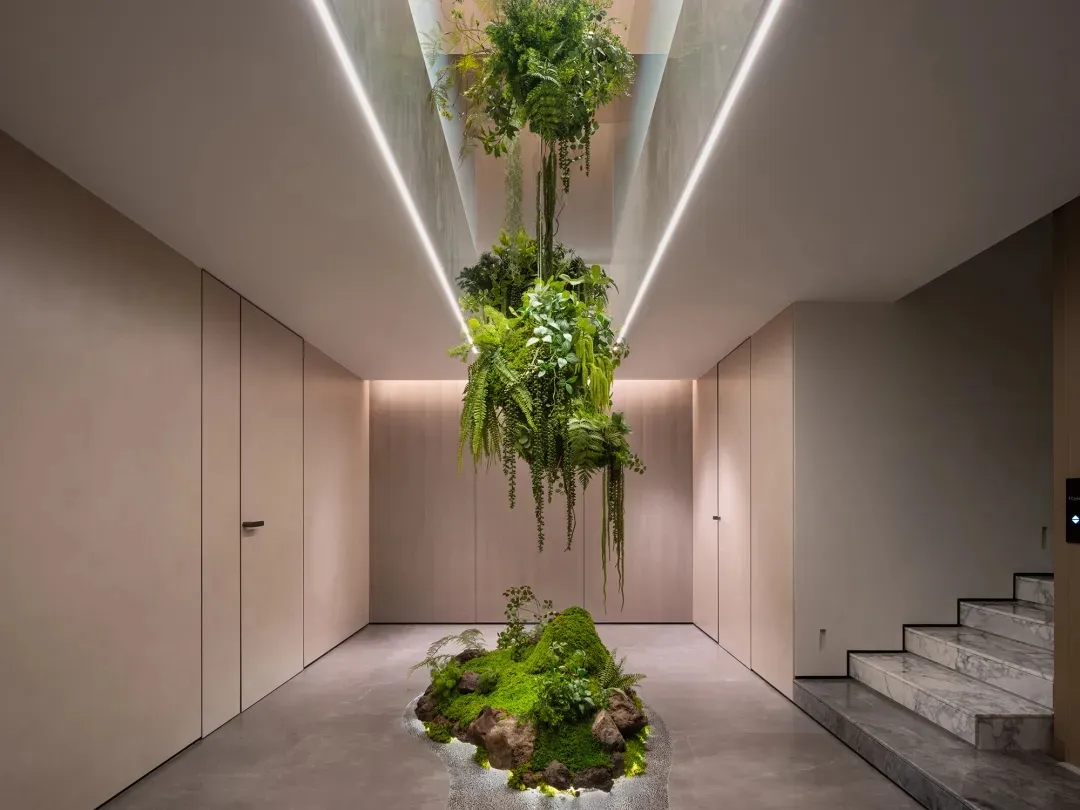A modern interior design featuring a living space with concrete detailing and potted plants.