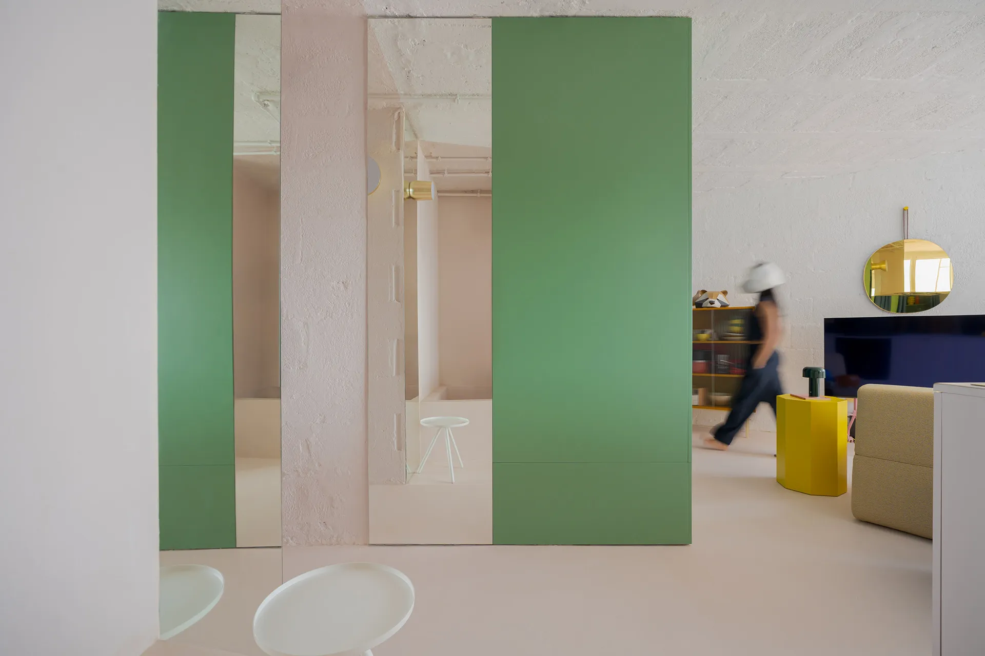 A modern interior with minimalist elements featuring a green panel wall.