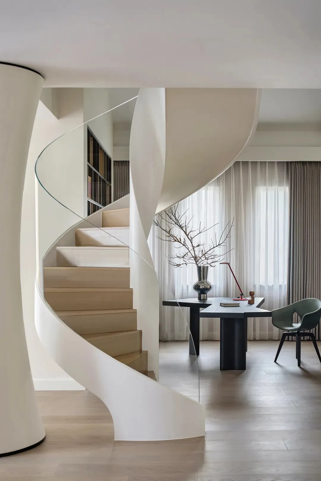 A modern residential office featuring minimalist design elements, including a spiral staircase, a desk, and a chair.