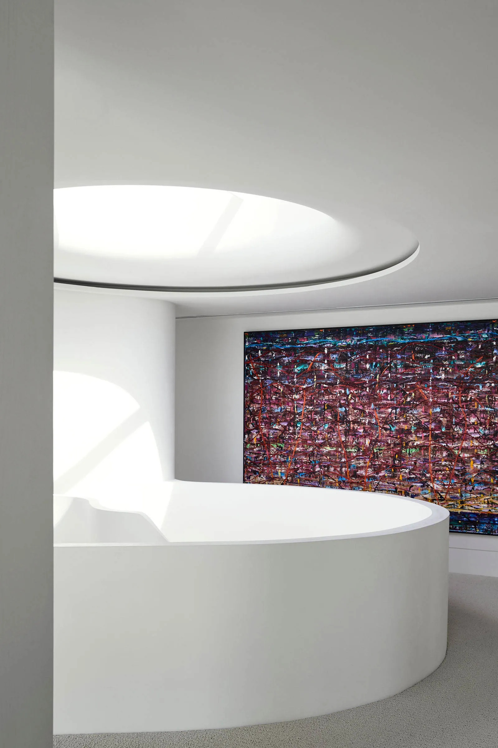 Modern interior design featuring sleek, white concrete walls and a large, abstract painting on the wall.