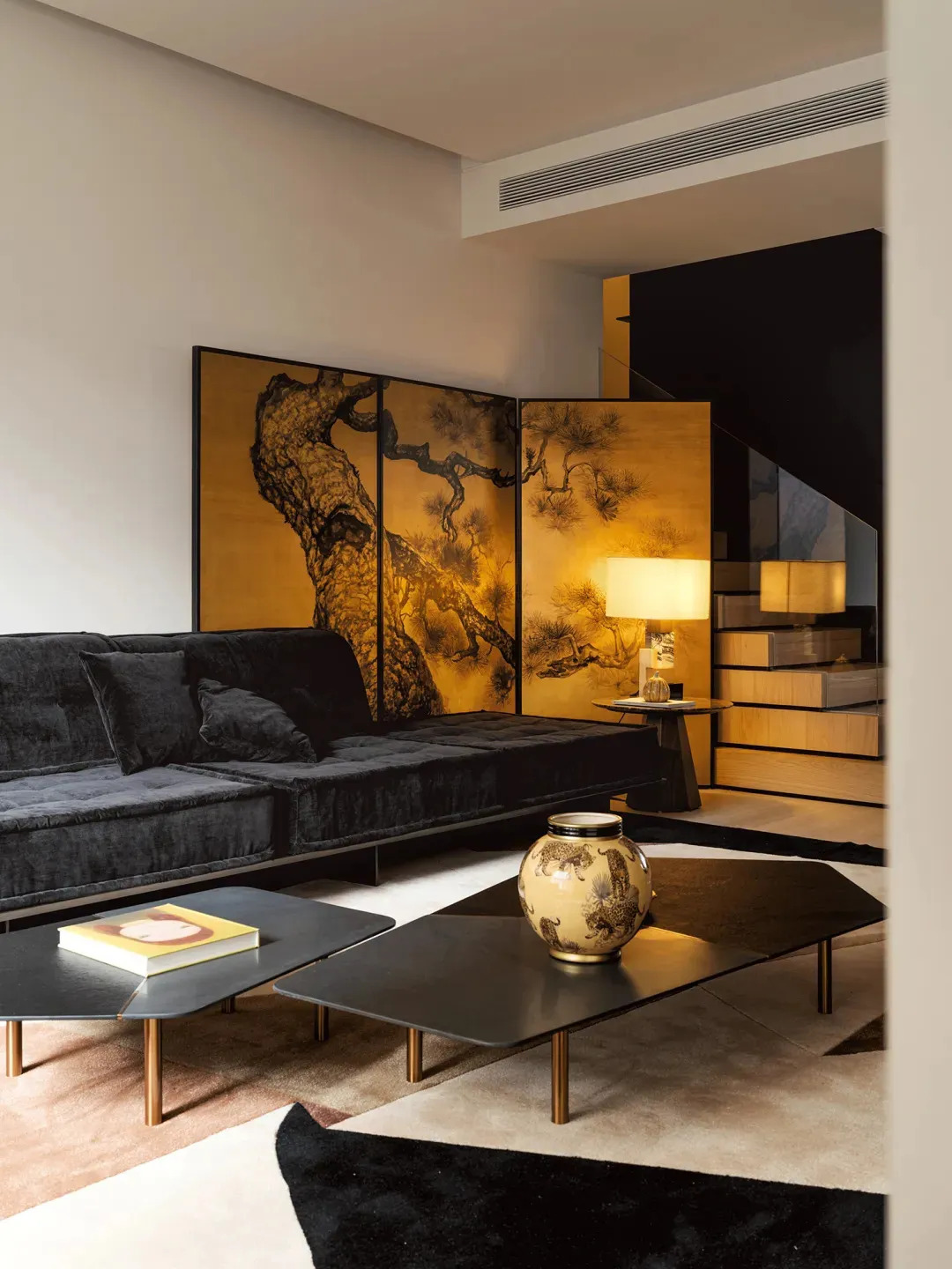 A modern living room featuring a black, textured sofa in a contemporary setting.